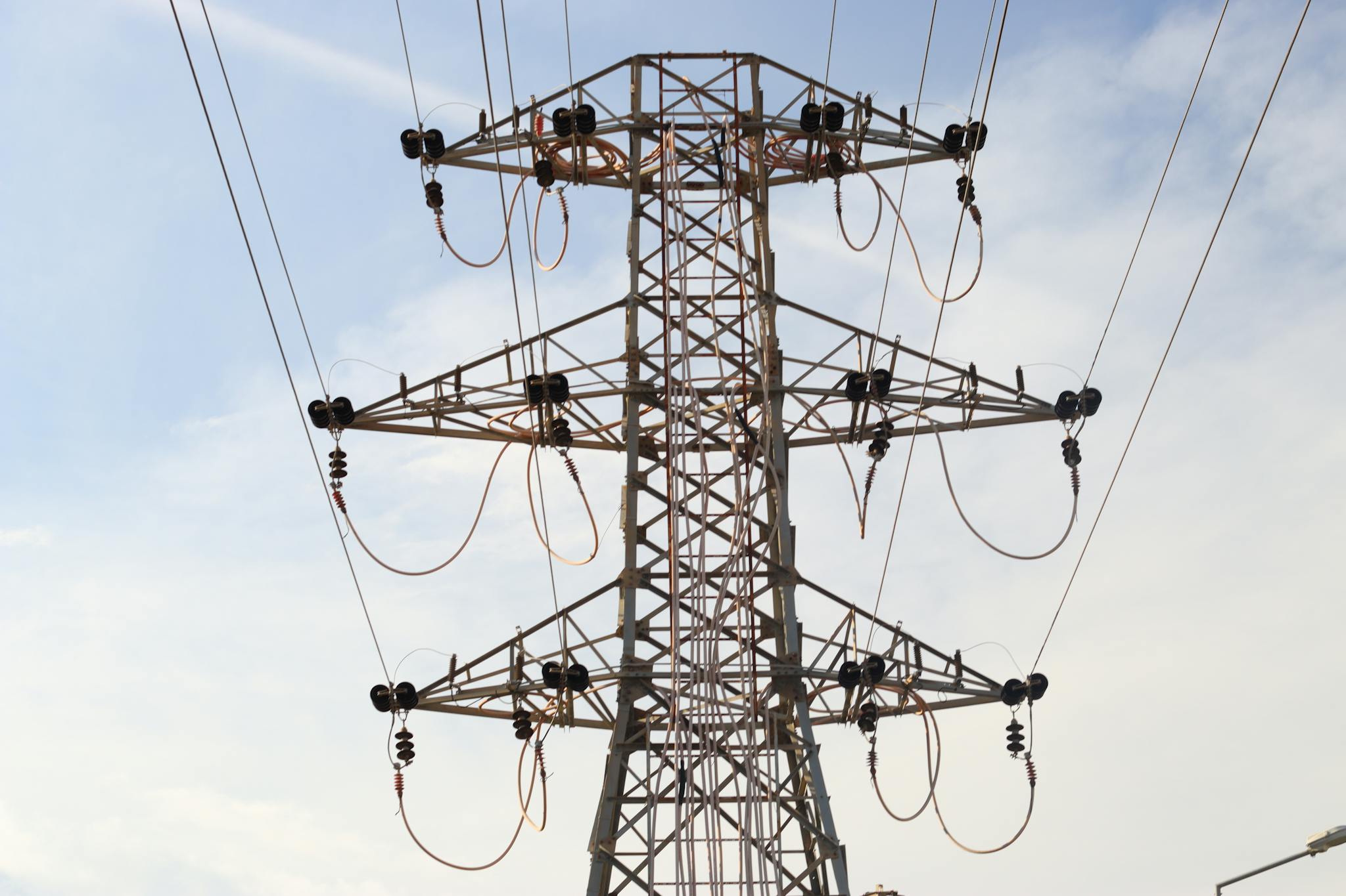Steel transmission tower with power lines extending across the sky, showcasing modern infrastructure.
